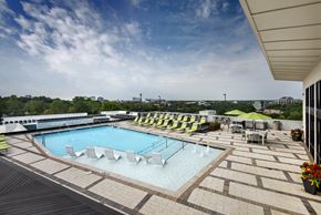 Atlanta apartment for rent - A large outdoor swimming pool with a wooden deck and lounge chairs.