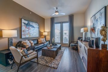 Irving apartment for rent - A living room with a chair, a couch, a coffee table, and a painting on the wall.