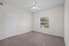 Killeen apartment for rent - an empty bedroom with a ceiling fan and a window