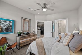 College Station apartment for rent - a bedroom with a large bed and a ceiling fan