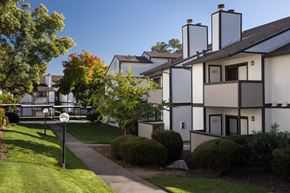 Rocklin apartment for rent - A white building with a black roof and a sign on the lawn.