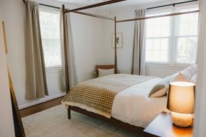 Nashville apartment for rent - A bedroom with a four poster bed and a table with a lamp on it.
