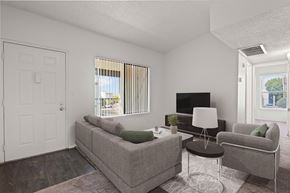 Yuma apartment for rent - A living room with a grey couch, a white lamp, and a television.