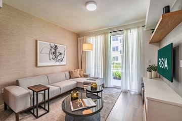 Miami apartment for rent - A living room with a sofa, a coffee table, and a painting on the wall.
