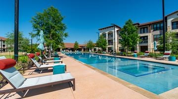 Georgetown apartment for rent - A pool surrounded by lounge chairs and umbrellas.