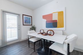Spring apartment for rent - a dining room with a white table and chairs and a window