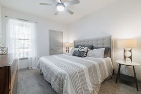 Spring apartment for rent - a bedroom with a bed and a ceiling fan