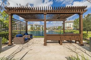 Spring apartment for rent - a patio with a pool and a wooden pergola