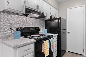 Tucson apartment for rent - A black stove top oven with a blue container on the counter.