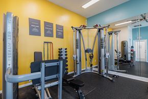 Houston apartment for rent - A gym with a yellow wall and a variety of equipment.