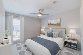Houston apartment for rent - A bedroom with a large bed and a painting on the wall.