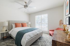 Houston apartment for rent - a bedroom with a bed and a ceiling fan