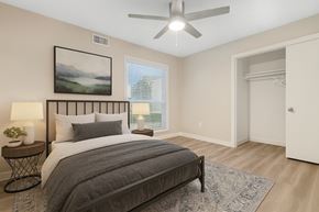 Dallas apartment for rent - A bedroom with a large bed and a ceiling fan.