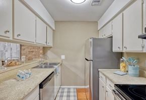 Austin apartment for rent - Gallery kitchen with white cabinetry and stainless steel appliances