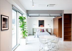 New Orleans apartment for rent - A modern bedroom with a bed, a chair, and a plant.