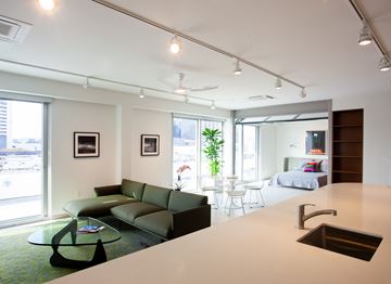 New Orleans apartment for rent - A modern living room with a green couch and a glass coffee table.
