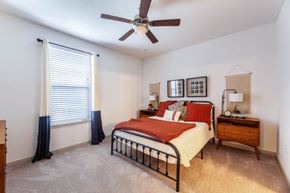 Grand Prairie apartment for rent - A bedroom with a bed, dresser, and window with curtains.