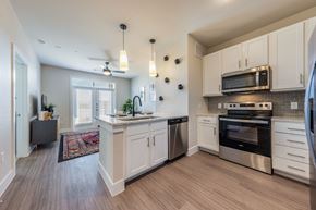 Austin apartment for rent - A kitchen with white cabinets and a wooden floor.