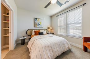Austin apartment for rent - A bedroom with a bed, a chair, and a painting on the wall.