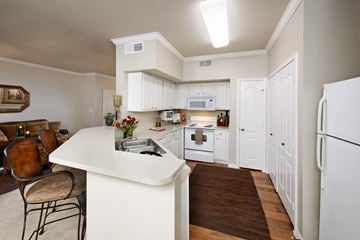 Flower Mound apartment for rent - A kitchen with white cabinets and a white refrigerator.