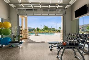 Bryan apartment for rent - A gym with a view of a pool and a playground.