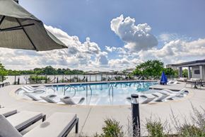 Nashville apartment for rent - A large outdoor swimming pool surrounded by lounge chairs and umbrellas.
