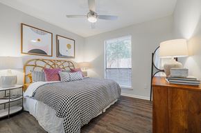 Houston apartment for rent - a bedroom with a large bed and a ceiling fan