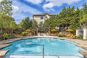 Dallas apartment for rent - a swimming pool with trees and a building in the background