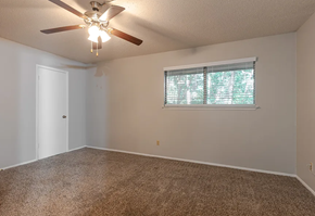 Longview apartment for rent - a bedroom with a ceiling fan and a window
