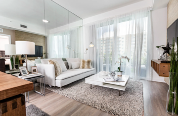 Decatur apartment for rent - A modern living room with a white sofa and a glass table.