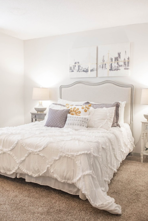 Antioch apartment for rent - a white bedroom with a bed and pillows and a painting on the wall