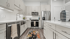 Austin apartment for rent - A modern kitchen with white cabinets and stainless steel appliances.
