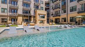 Austin apartment for rent - A swimming pool with loungers and a building in the background.