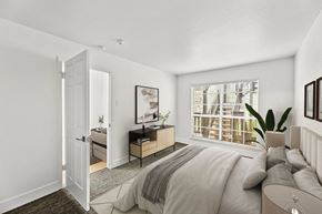 Austin apartment for rent - A bedroom with a large bed and a window with blinds.