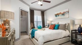 Carrollton apartment for rent - A bedroom with a large bed and a ceiling fan.