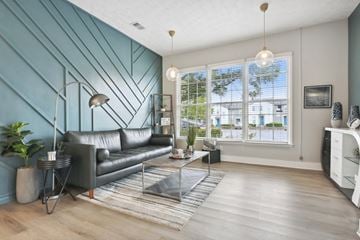 Marietta apartment for rent - A living room with a black leather sofa and a grey rug.