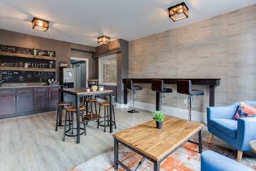 Atlanta apartment for rent - a living room with a bar and a dining area with chairs and tables