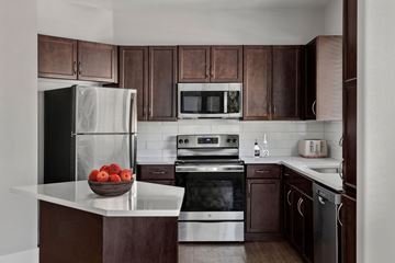 Surprise apartment for rent - A kitchen with brown cabinets and a black refrigerator.