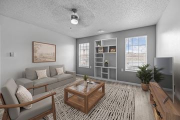 El Paso apartment for rent - A living room with a grey couch, a wooden coffee table, and a painting on the wall.