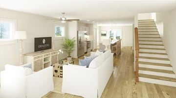 Charlotte townhouse for rent - A living room with a white couch and a wooden staircase.