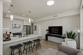 San Diego apartment for rent - A modern kitchen with a bar stool and a sign that says 800 Broadway.