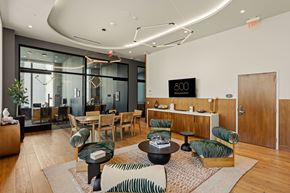 San Diego apartment for rent - A modern living room with a glass wall and a wooden floor.