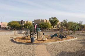 Surprise townhouse for rent - A playground with a yellow slide and a green tree.