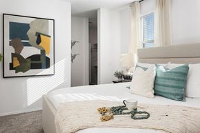 Surprise townhouse for rent - a bedroom with a bed and pillows and a painting on the wall