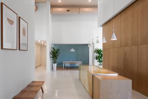 St. Petersburg apartment for rent - A modern office space with a long wooden reception desk and two framed pictures on the wall.