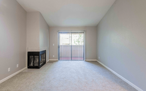 Rocklin apartment for rent - A spacious living room with a fireplace and a carpeted floor.