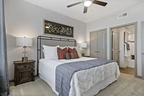 College Station apartment for rent - A bedroom with a large bed and a ceiling fan.