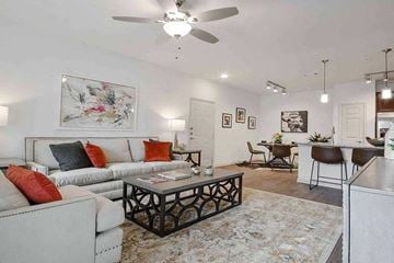 Granbury apartment for rent - A living room with a white couch, a coffee table, and a painting on the wall.