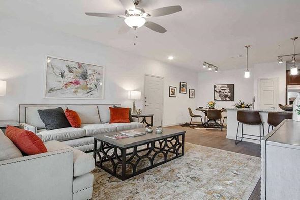 Granbury apartment for rent - A living room with a white couch, a coffee table, and a painting on the wall.