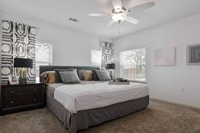 Granbury apartment for rent - A bedroom with a large bed and a ceiling fan.